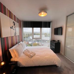 um quarto com uma cama e uma grande janela em K D Tower Lux Apartment em Hemel Hempstead