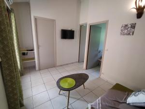 a living room with a green chair and a couch at Ti Village Creole in Sainte-Anne