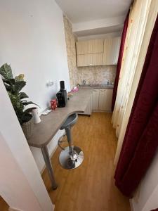 a kitchen with a table and a stool in a room at Brasov Place in Braşov