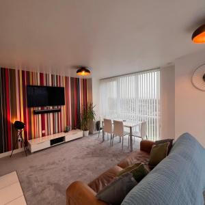 a living room with a couch and a table at K D Tower Lux Apartment in Hemel Hempstead
