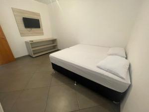 a small bedroom with a bed and a tv at Cristal casa de vidro in São Thomé das Letras