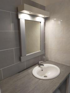 a bathroom with a sink and a mirror at Ti Village Creole in Sainte-Anne