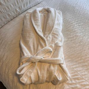 a white towel sitting on top of a bed at K D Tower Lux Apartment in Hemel Hempstead