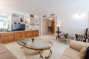 a living room with a glass table and a couch at Deluxe Apartment on the First Line in Marbella