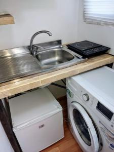 a kitchen with a sink and a washing machine at Front Garden Cabin Home with Terrace(Self Check-in) 
