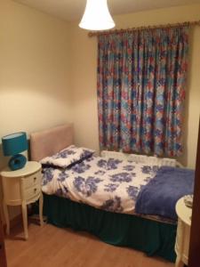 a small bedroom with a bed and a window at Primrose Cottage, Bushmills - Cosy Self Catering Property in Bushmills