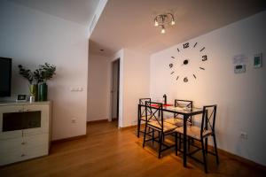 a room with a table and a clock on the wall at Orillas del Castillo in Alicante