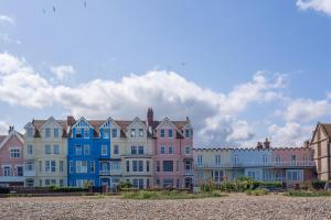 a row of colorful houses on the beach at Hideaway Cottage in Leiston