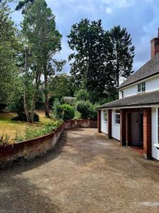 a driveway in front of a white house at Stunning 2 bedroom cottage on the River Wensum in Earlham