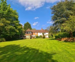 a house with a large lawn in front of it at Stunning 2 bedroom cottage on the River Wensum in Earlham