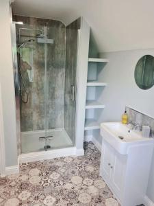 a bathroom with a shower and a sink at Stunning 2 bedroom cottage on the River Wensum in Earlham