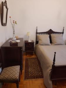 1 dormitorio con 1 cama, 1 mesa y 1 silla en Casa da Tia Lena, en Coímbra