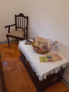 una mesa con una cesta encima con una silla en Casa da Tia Lena, en Coímbra