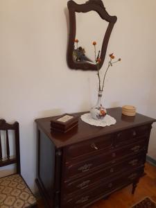 a dresser with a mirror and a vase on it at Casa da Tia Lena in Coimbra