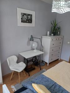 una camera da letto con scrivania, sedia e cassettiera di W Krakowie u Helenki a Cracovia