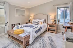 a bedroom with a bed and a table and a window at Luxe Laguna Home with Ocean View Walk to Beach in Laguna Beach