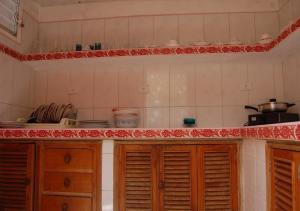 a kitchen with wooden cabinets and red and white tiles at Hostal Bitton Appartement 3 in Trinidad