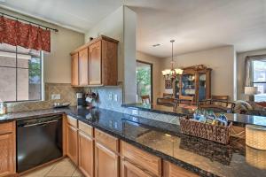 a kitchen with wooden cabinets and black counter tops at Goodyear Desert Oasis Walk to Community Pool in Goodyear