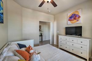 a bedroom with a bed and a flat screen tv at Goodyear Desert Oasis Walk to Community Pool in Goodyear