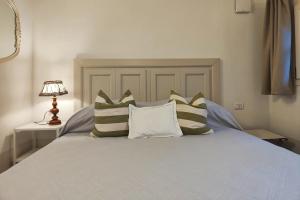 a bedroom with a bed with pillows on it at Il Cortiletto - Suites & Apartments in Pistoia