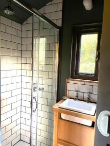 a bathroom with a sink and a shower at Old King William Shepherd Huts and Private Hot Tubs in North Norfolk in Hunworth