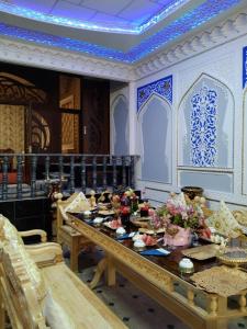 a dining room with a table with food on it at Hotel Rizqiro'z Boutique in Bukhara