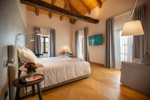 um quarto com uma cama e uma mesa com um candeeiro em Villaggio Narrante - Cascina Galarej em Sorano