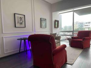 a living room with a red chair and a table at Classy Loft near Polanco w/ balcony in Mexico City
