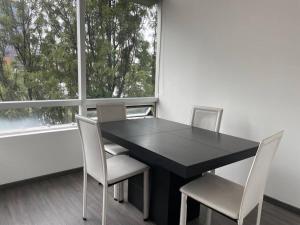 a black table and chairs in a room with a window at Classy Loft near Polanco w/ balcony in Mexico City