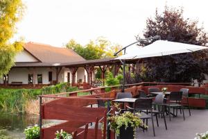 un patio con mesas, sillas y una sombrilla en Hotel Nenufar en Kościan