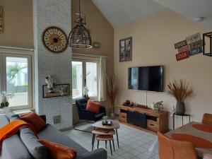 a living room with a couch and a tv at The Beach House in Middelkerke