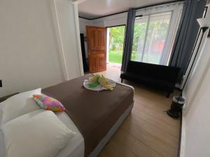 um quarto com uma cama e uma mesa com um prato em Aracari Garden Hostel em Tortuguero