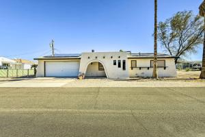 an old white house with an open garage at Bullhead City Home - Near Colorado River! in Bullhead City