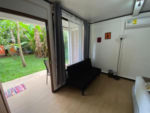 a living room with a sliding glass door and a chair at Aracari Garden Hostel in Tortuguero