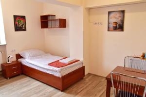 ein kleines Schlafzimmer mit einem Bett und einem Tisch in der Unterkunft Noclegi GALESZ in Świdnica
