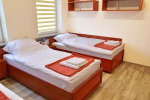 Dos camas en una habitación con toallas. en Noclegi GALESZ, en Świdnica