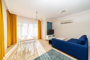 ein Wohnzimmer mit einem blauen Sofa und einem Tisch in der Unterkunft Flat with Balcony and Shared Pool in Belek in Belek