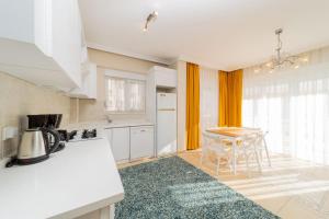 a kitchen with white appliances and a table with chairs at Flat with Balcony and Shared Pool in Belek in Belek
