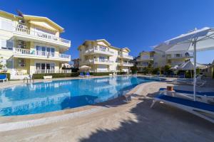 a swimming pool in front of some apartment buildings at Flat with Balcony and Shared Pool in Belek in Belek
