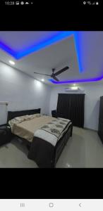 1 dormitorio con 1 cama y techo azul en Rain Homestay, en Alleppey