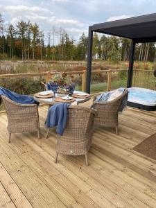 a patio with a table and chairs on a deck at Holicarrs - Gingerlily in Riccall