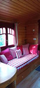 a couch in a log cabin with a table at AU NID DOUILLET DE LA FERME CHAUVET in Chantenay-Villedieu