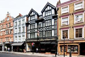 een zwart-wit gebouw in een stadsstraat bij F4 Greek Street by City Living London in Londen