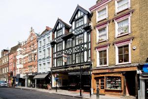 een gebouw in een stadsstraat met gebouwen bij F4 Greek Street by City Living London in Londen