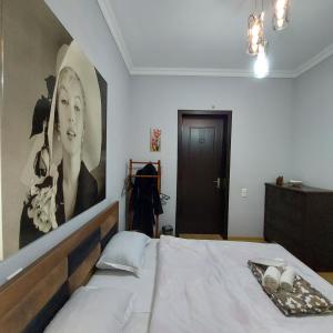 a bedroom with a bed with a large picture on the wall at Guesthouse different in Tbilisi City