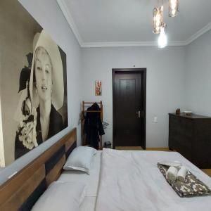 1 dormitorio con 1 cama con un gran cuadro en la pared en Guesthouse different en Tiflis