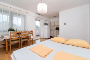 - une cuisine et une salle à manger avec 2 lits et une table dans l'établissement Apartment Sokol, à Batalaži