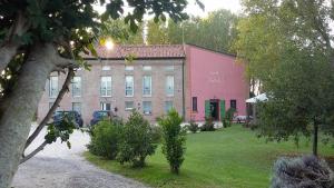 a large brick building with a pink building at Corte Stellata Holiday Apartments in Stellata