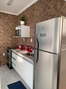 uma cozinha com um frigorífico de aço inoxidável em Cobertura Pé na Areia e Incrível Vista Para a Praia em São Vicente