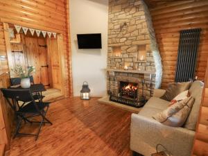 a living room with a couch and a fireplace at Whitemoor Lodge in Barnoldswick